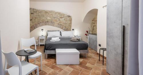 a bedroom with a bed and a table and chairs at Locazione Turistica Via Saffi 10 Gubbio in Gubbio