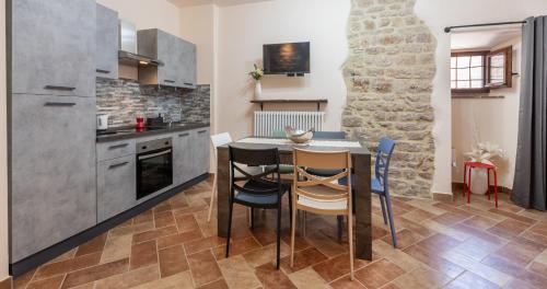 a kitchen with a table and chairs in a room at Locazione Turistica Via Saffi 10 Gubbio in Gubbio