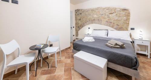 a bedroom with a bed and a table and chairs at Locazione Turistica Via Saffi 10 Gubbio in Gubbio
