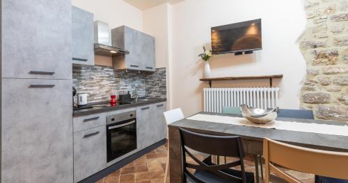 a kitchen with a table with chairs and a counter at Locazione Turistica Via Saffi 10 Gubbio in Gubbio
