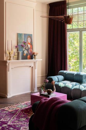 a living room with a blue couch and a table at Luxurious boutique apartment near city centre in Groningen