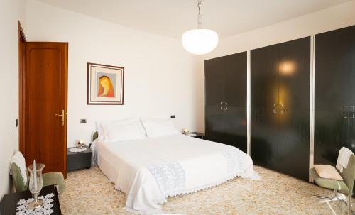 a bedroom with a white bed and a black closet at Villa Celeste in Lucca