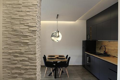 a dining room with a table and chairs in a kitchen at Lux Apartman JELAČIK in Subotica