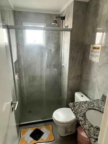 ein Badezimmer mit Dusche, Toilette und Waschbecken in der Unterkunft Apartamento Guarujá Lazer completo Villa Di Fiori 600mts da praia in Guarujá