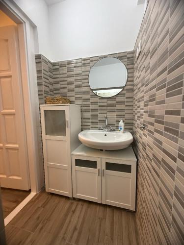 a bathroom with a sink and a mirror at Offline Vendégház in Orfű