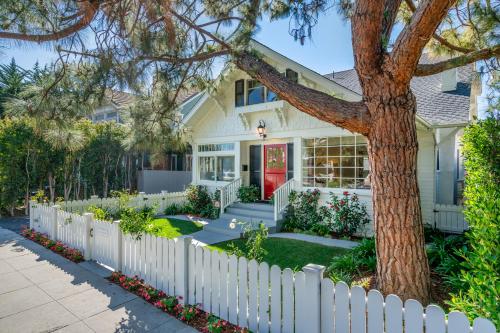 a white picket fence in front of a white house at The Sea Captains House & Loft by Paradise Retreats in Santa Barbara