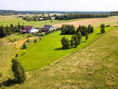 an aerial view of a field with houses and trees at Dom na mazurach, sauna, jacuzzi, jezioro Garbas, łódka, 5 sypialni in Liski