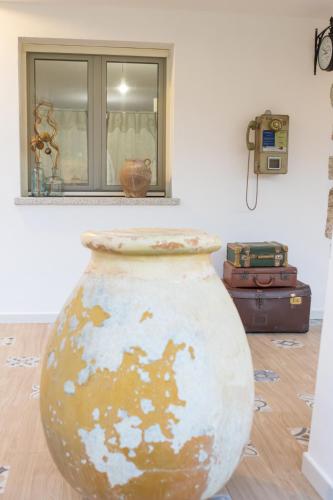a large vase sitting on the floor in a room at Dimora S'Ena Manna in Oliena