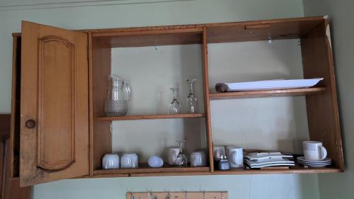 a wooden cabinet with dishes and vases in it at J and A Villas Homestay in Mbale
