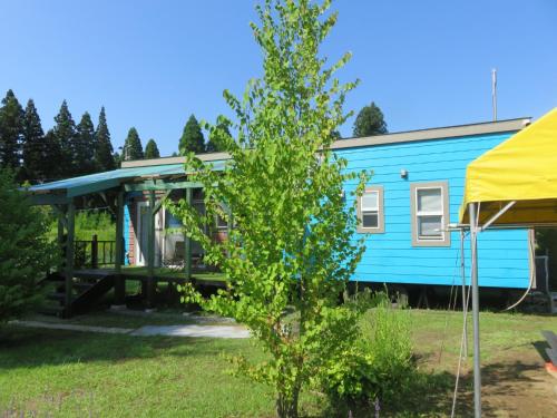 a blue house with a porch next to a tree at Wildcat - Vacation STAY 95961v in Sasakura