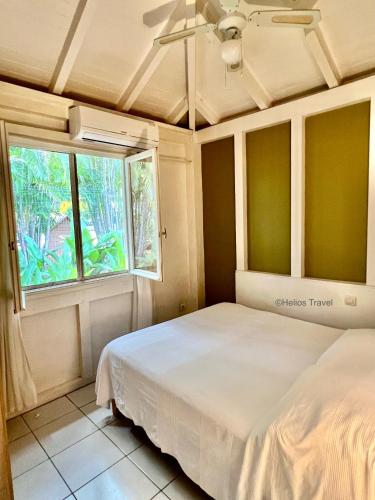 a bedroom with a bed and a window at Villa Mabouya Fort Royal in Deshaies