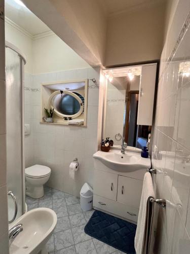 a bathroom with a sink and a toilet and a mirror at La casina di Tata in Terricciola