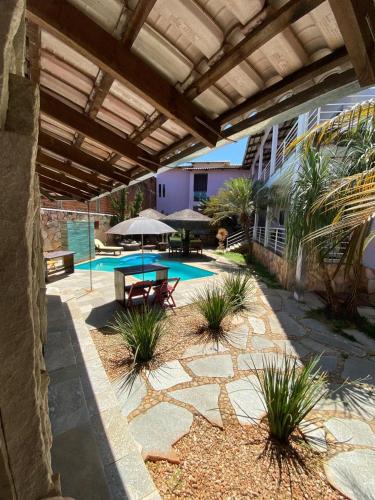 a patio with a table and a swimming pool at Pousada Aliany Lôbo in Pirenópolis