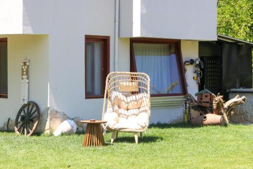 a wicker chair sitting in the grass in front of a house at Mints Hotel Ağva in Agva