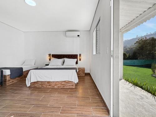 En eller flere senge i et værelse på Sítio com Churrasqueira, Piscina, Lago e Natureza