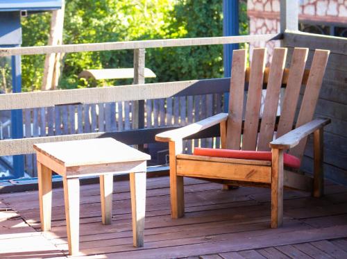 a wooden chair and a stool sitting on a deck at Mints Hotel Ağva in Agva
