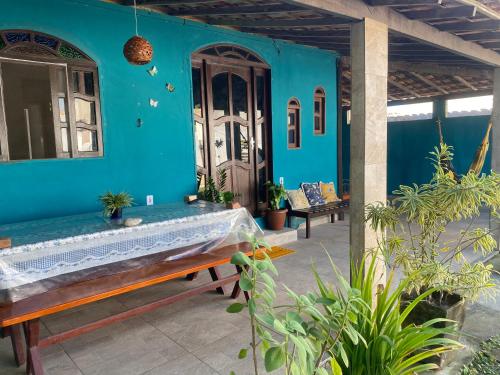 a blue house with a bench on a patio at Casa unamar, cabo frio - RJ in Cabo Frio