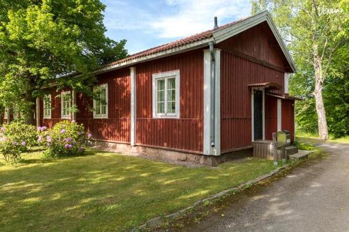 a small red house with a grass yard at Ala-Lemun kartano in Kaarina