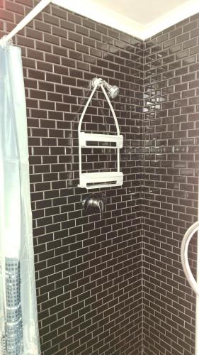 a black tiled shower with a bird cage on the wall at Serenity in Windhoek