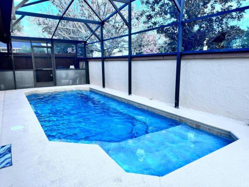 a swimming pool with blue water in a building at 3Q/2B Perto da DISNEY, Piscina Privativa in Kissimmee