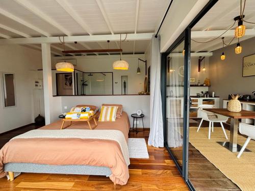 a bedroom with a bed and a dining room at ZANNANNA LODGE in Le Diamant