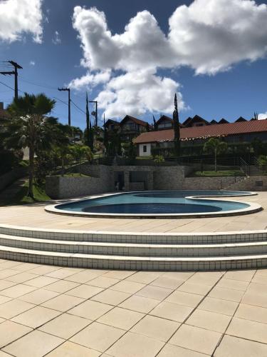 a large circular pool in a park with trees and buildings at Condomínio Serra Nevada - Chalé 202 in Bananeiras