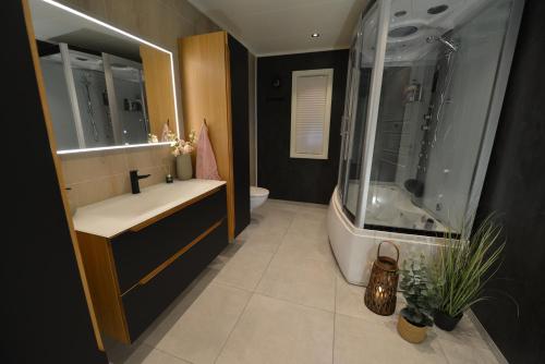 a bathroom with a tub and a sink and a shower at Senja Beach Lodge in Senja