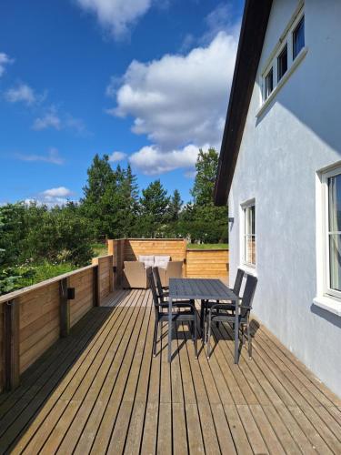 a wooden deck with a table and chairs on it at Hallfreðarstaðir 1 Apartments in Hallfreðarstaðir