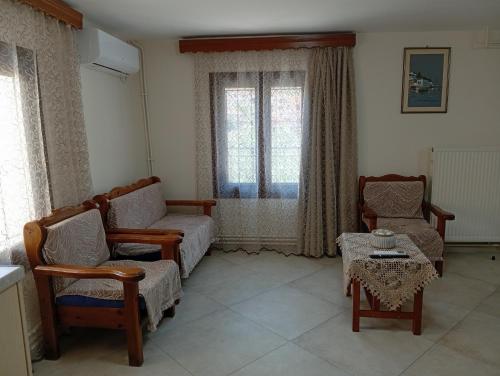 sala de estar con 2 sillas, sofá y mesa en Eirini's House, en Leonidio