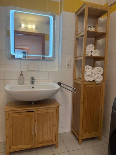 a bathroom with a sink and a mirror and towels at Romantisches und großes Apartment in Dobl bei Graz EG D01 in Dietersdorf