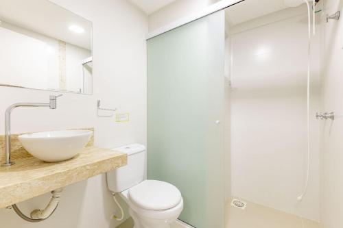 a bathroom with a toilet and a sink and a shower at Apto Confortável e Econômico na Praia de Bombas in Bombas