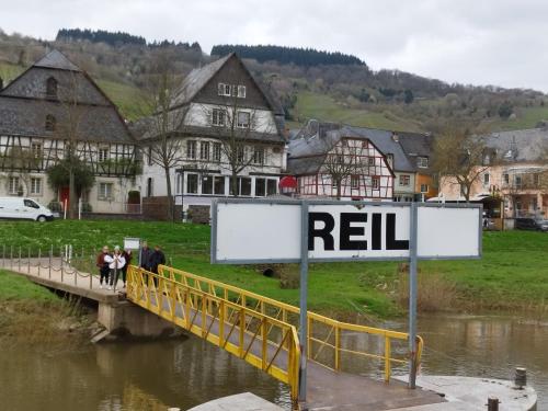 a bridge over a river with a sign that reads reelin at Ferienwohnung Moselherz in Reil