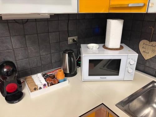 a kitchen counter with a microwave on a counter top at Number one for hospitality Milano Navigli in Milan