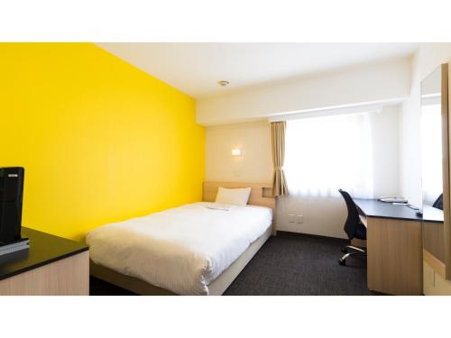 a hotel room with a bed and a desk and a window at Smile Hotel Utsunomiya Higashiguchi - Vacation STAY 00203v in Utsunomiya