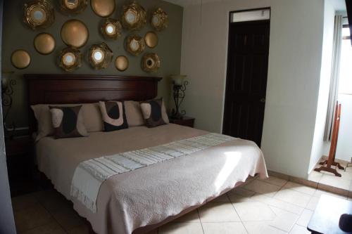 a bedroom with a large bed with plates on the wall at Hotel del Centro in Bernal