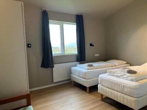 a room with two beds and a window at Álfheimar Hotel in Borgarfjordur Eystri
