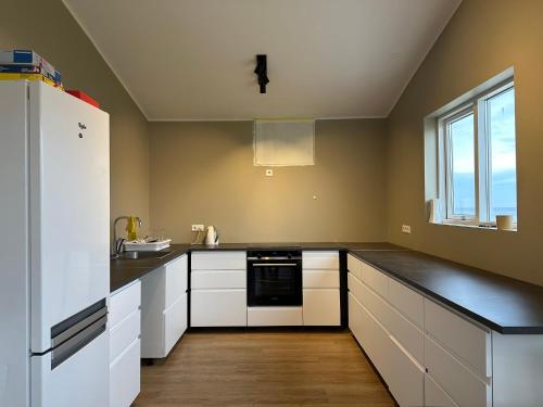 a kitchen with white cabinets and a white refrigerator at Álfheimar Hotel in Borgarfjordur Eystri