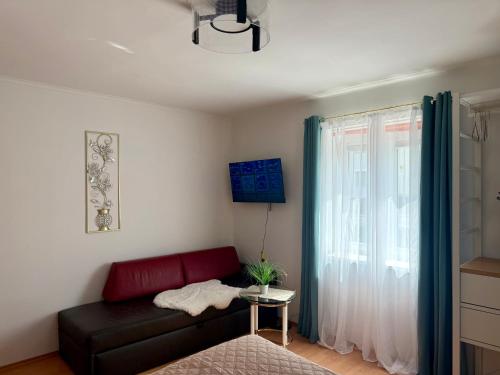 a living room with a red couch and a window at Romantisches und großes Apartment in Dobl bei Graz EG D01 in Dietersdorf