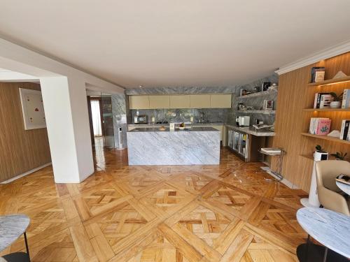 een woonkamer met een houten vloer en een keuken bij Residence L Heritage Tennyson in Mexico-Stad