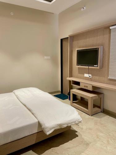a bedroom with a bed and a flat screen tv at HOTEL HERITAGE Inn in Indore