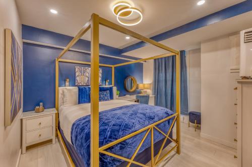 a bedroom with a canopy bed and blue walls at Art Deco Broadway Queen Room in Vancouver