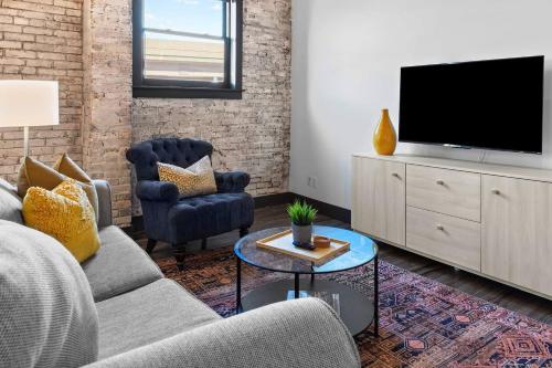 a living room with a couch and a tv at Brick & Bed Riverfront Lofts, PC 101 in Saint Louis