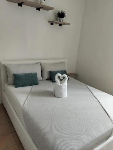 a white bed with a heart shaped towel on it at La Casa Vacanze di Byron in Gorizia