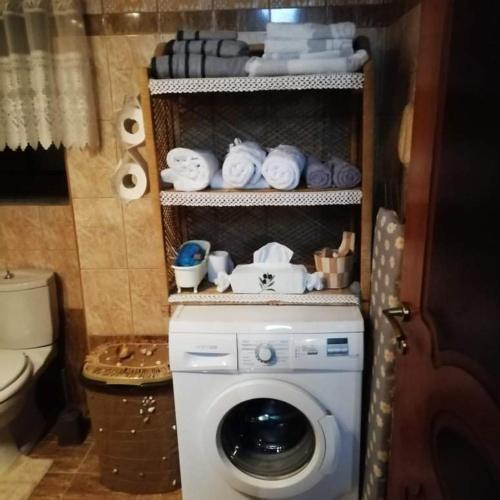 a washing machine in a bathroom with towels at Beautiful stone house in Samos in Samos
