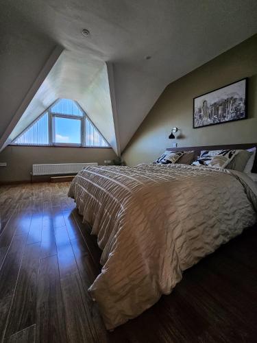 a bedroom with a large bed with a large window at Beachside - Stunning sea view townhouse across the road from the beach in Kilkeel