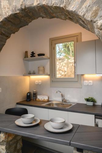 a kitchen with a counter with two bowls on it at Omnia Apartments Amorgos Studio in Amorgos