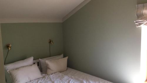 a bedroom with a bed with white sheets and pillows at Stylish Loft Apartment on a Country Farm in Bad Fallingbostel