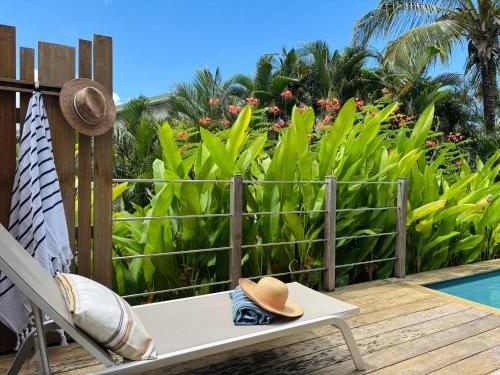 a hat sitting on a chair next to a pool at ZANNANNA LODGE in Le Diamant