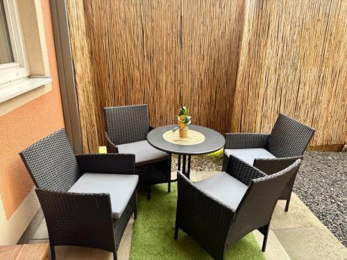 a patio with chairs and a table with a vase on it at Romantisches und großes Apartment in Dobl bei Graz EG D01 in Dietersdorf