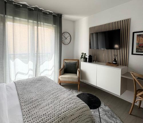 a bedroom with a bed and a tv and a chair at Studio Galerie 473 L'art de vivre à Metz in Metz